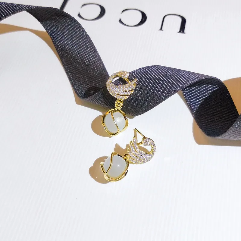 Elegantes pendientes de cisne de cristal con detalles dorados