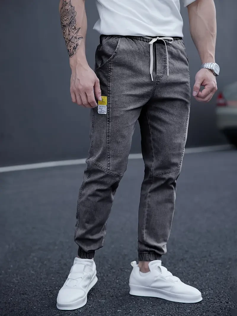 Vaqueros deportivos elegantes de corte cónico para hombre: cintura con cordón ajustable, ropa urbana versátil para el día a día.