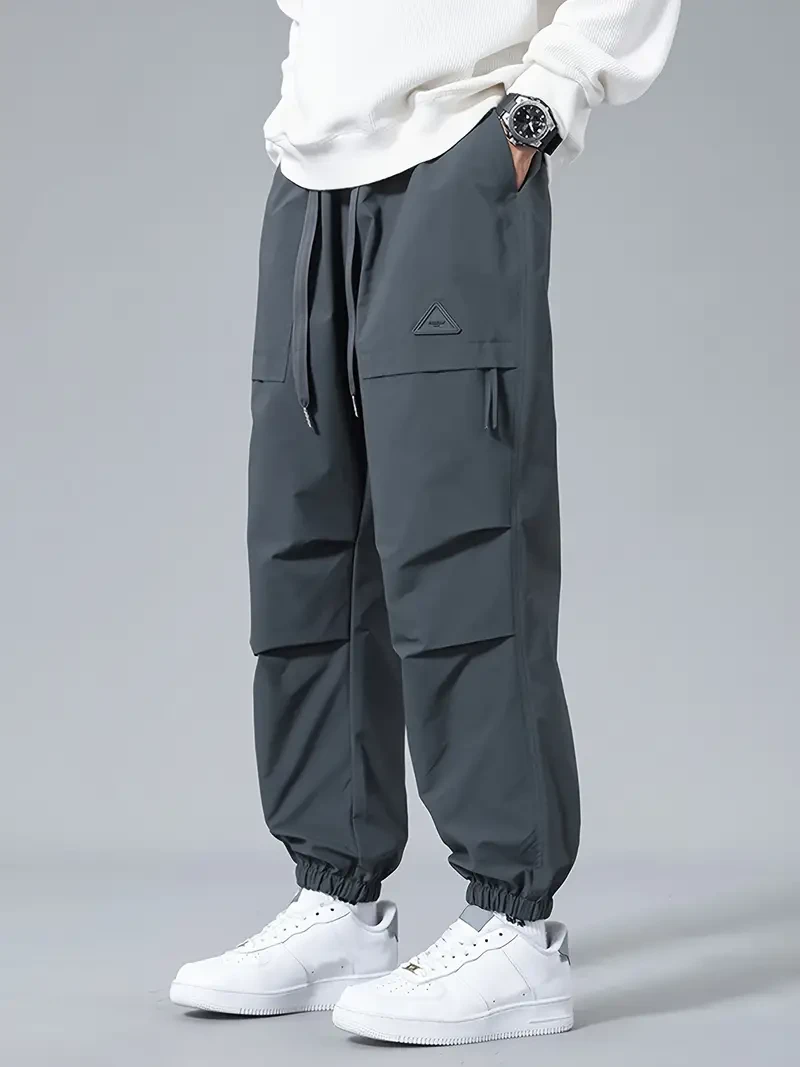 Pantalones cortos cargo para hombre con puños, cordón y bolsillos en color liso, corte holgado y moderno para uso informal.