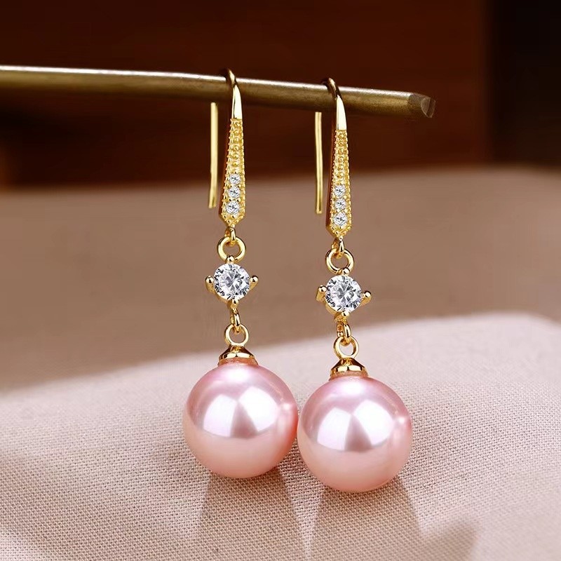 Elegantes pendientes de perla con detalles de circonitas que realzan la belleza de la joyería dorada.