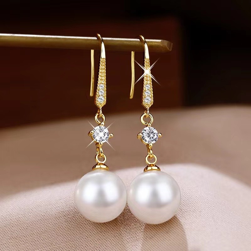 Elegantes pendientes de perla con detalles de circonitas que realzan la belleza de la joyería dorada.