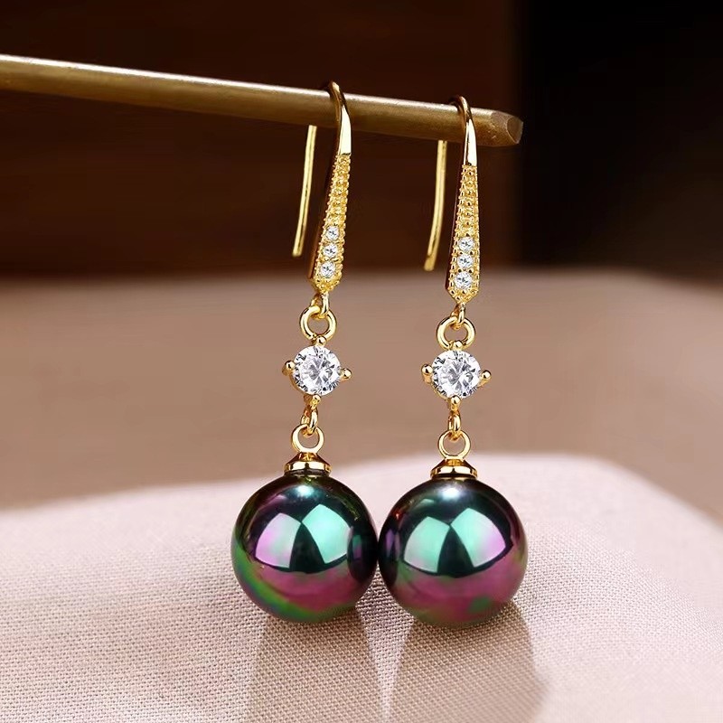 Elegantes pendientes de perla con detalles de circonitas que realzan la belleza de la joyería dorada.