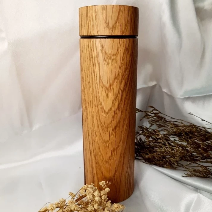 Estético juego de termo y taza fabricado en madera de teca recubierto de acero inoxidable.