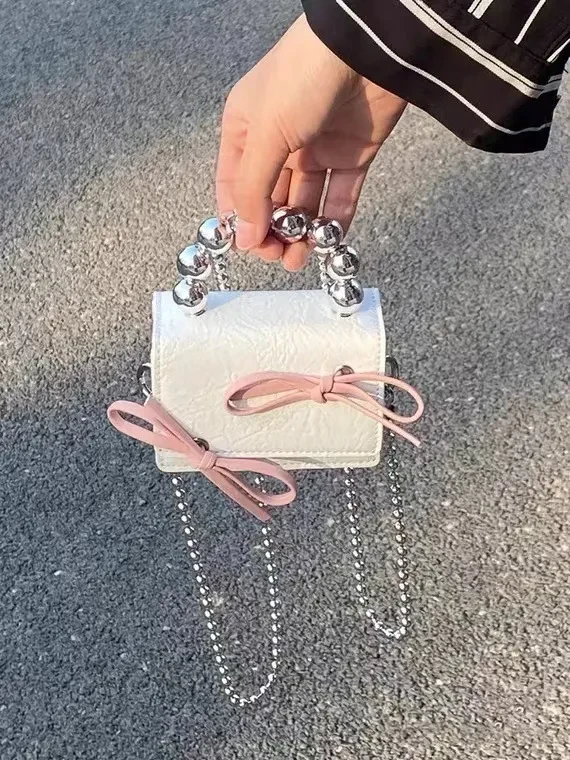 Mini bolso de mano con cadena y lazo texturizado