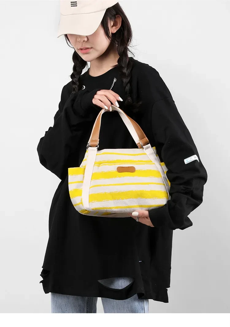 Bolso de mano de lona a rayas de gran capacidad con un solo hombro y almacenamiento para exteriores.