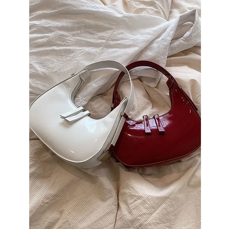 Bolso de hombro bajo el brazo, moderno, sencillo y con textura en forma de media luna.