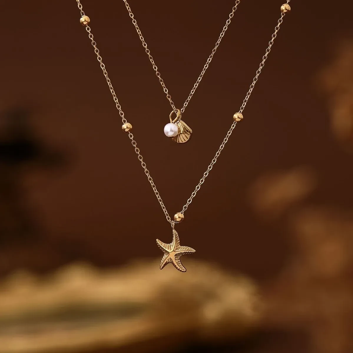 Collar de concha de estrella de mar de doble capa con alta retención de color en acero de titanio y baño de vapor al vacío en oro de 18 quilates.