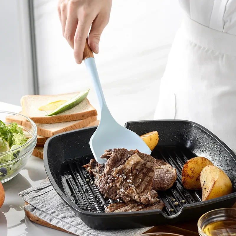 Juego de utensilios de cocina de silicona con mango de madera de color blanco cremoso
