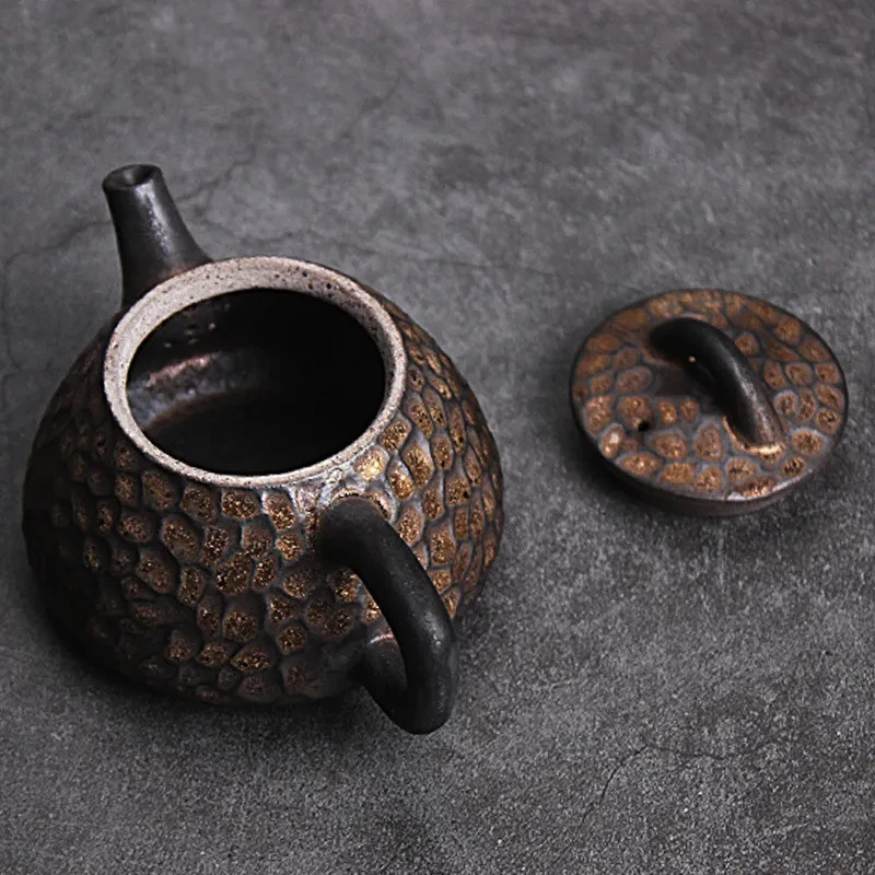 Tetera de cerámica japonesa con piedra de martillo dorada y negra