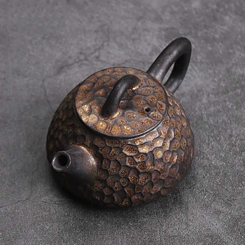 Tetera de cerámica japonesa con piedra de martillo dorada y negra