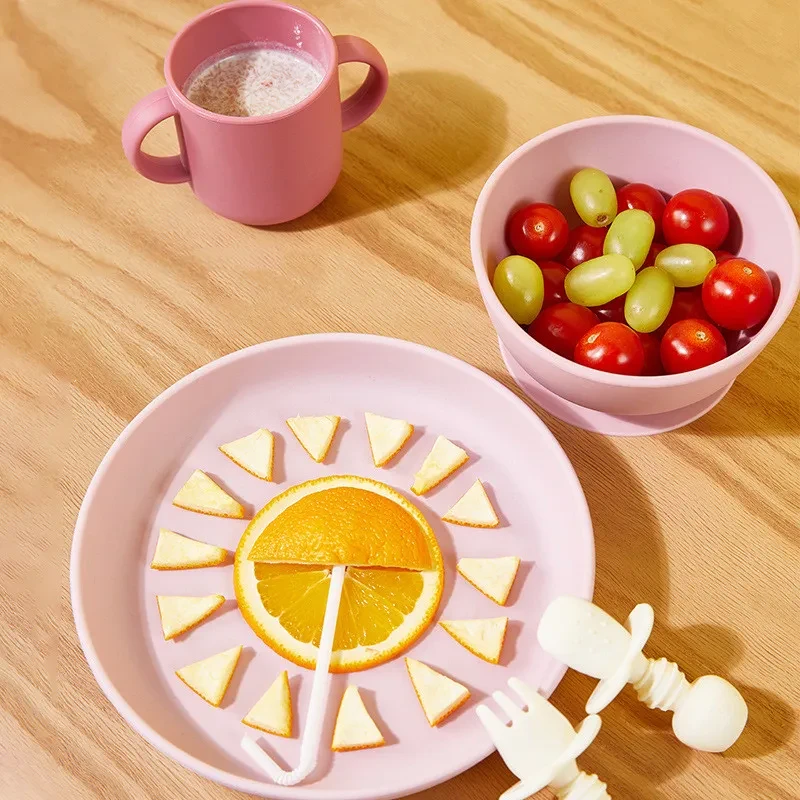 Juego de cubiertos para niños con cuchara de silicona y recipiente anticaídas para llenar con agua.