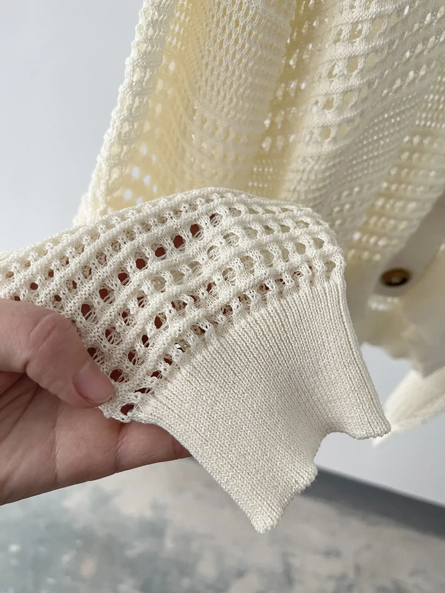 Suéter tipo cárdigan blanco con huecos dignos para uso exterior